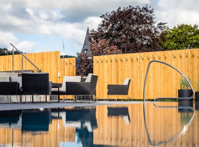 Ein Poolbereich mit Loungemöbeln.