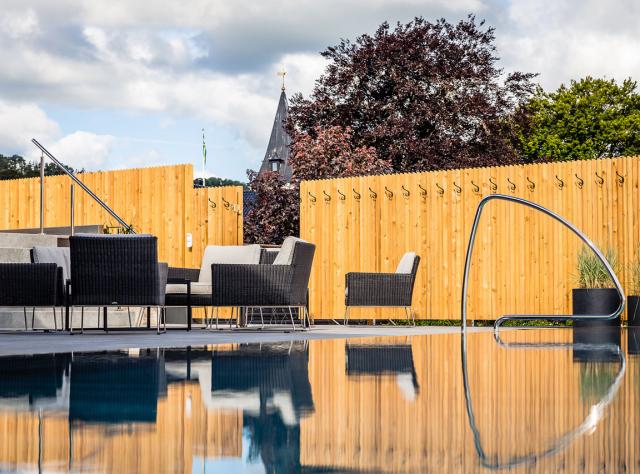 A pool area with lounge furniture.