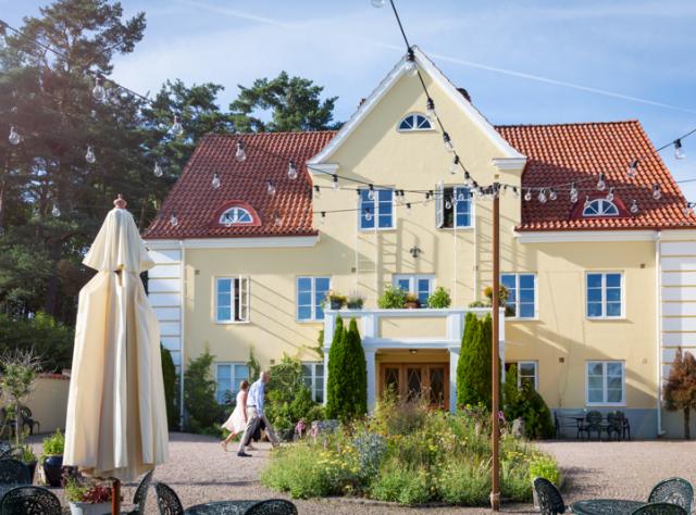Light yellow house with outdoor seating area on the front yard during early summer weather