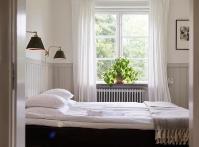 hotel room in an older house with white walls and crisp white bedding