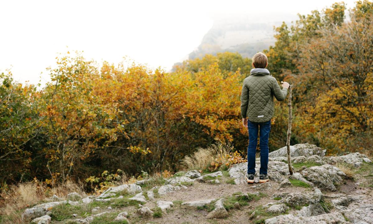 boy looking out over the sea in an autumn setting